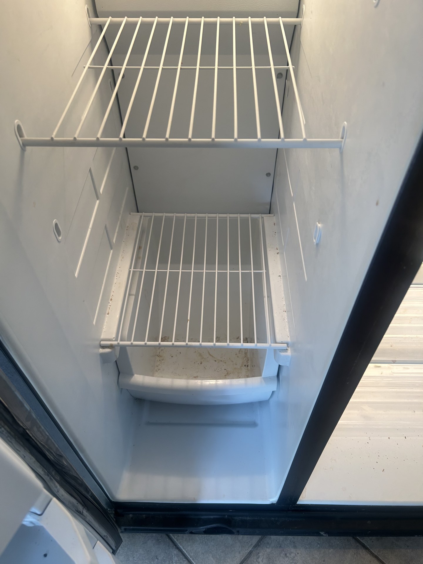 Refrigerator interior before deep cleaning with visible grime on the shelves